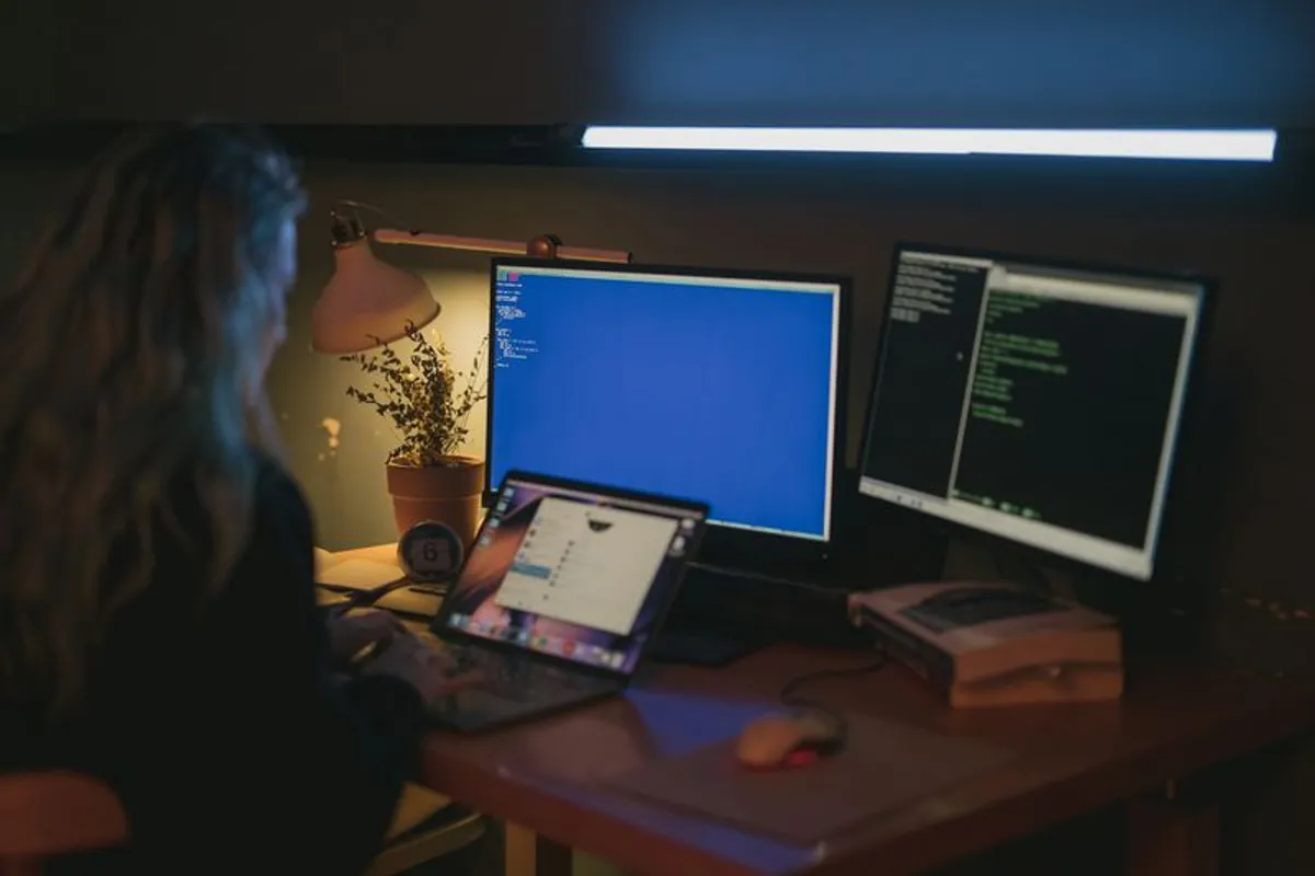 Frau arbeitet spaetabends am Computer – langes Arbeiten am Bildschirm trocknet die Augen aus